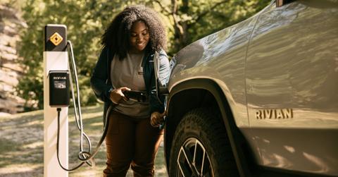 Woman charging a Rivian vehicle