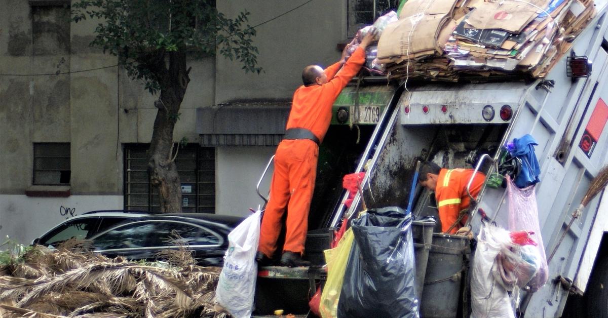 Two garbage men working.