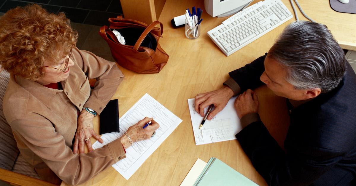 Banker helps elderly woman complete a loan