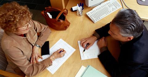Banker helps elderly woman complete a loan