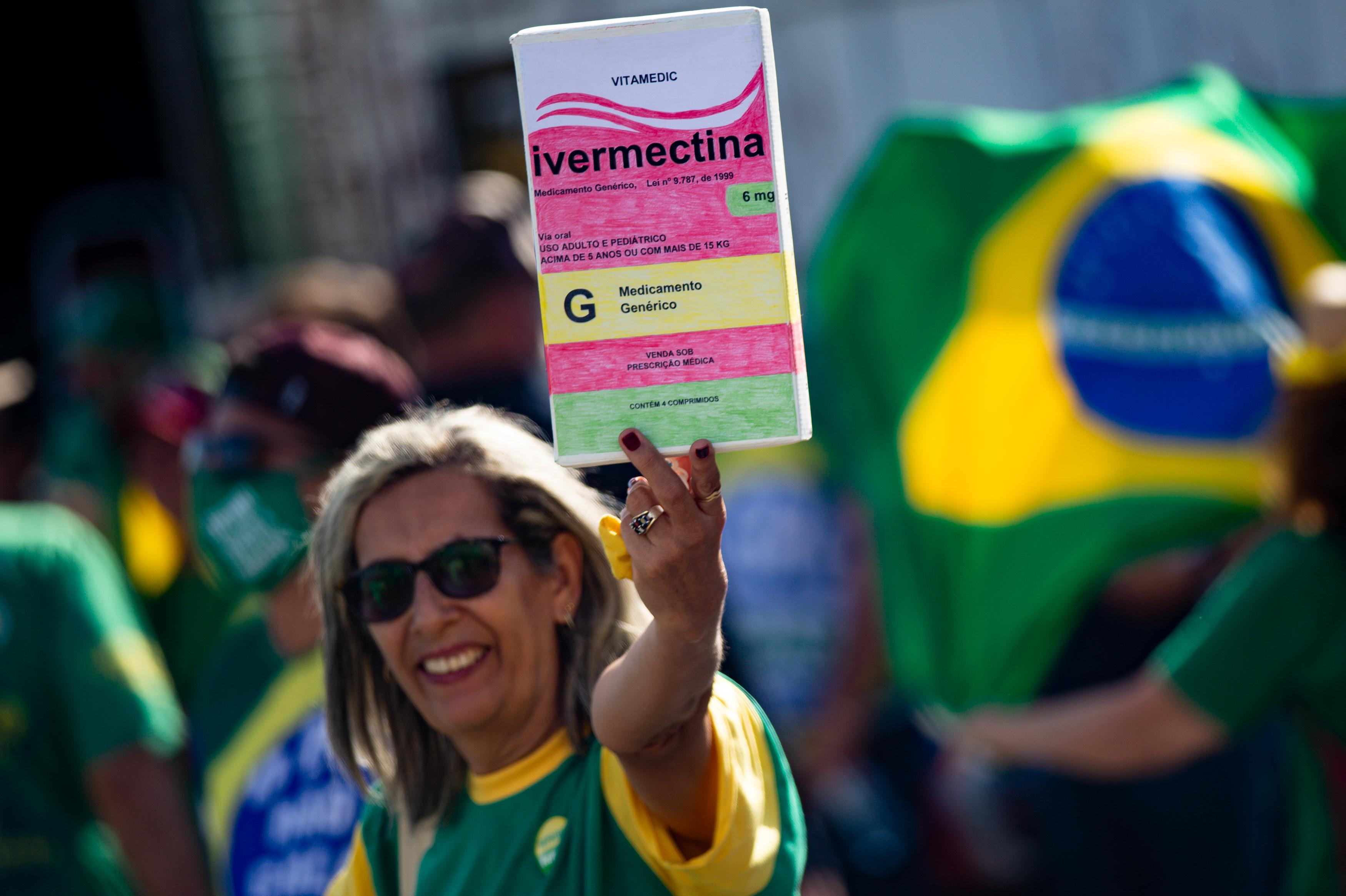 A person holding an ivermectin sign