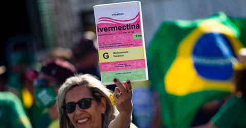 A person holding an ivermectin sign