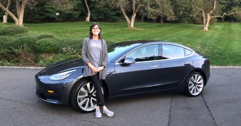 ARK Invest CEO Cathie Wood posing with a car