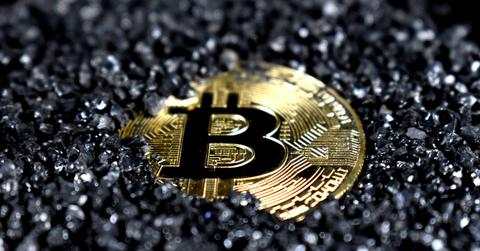 A Bitcoin covered in black crystals.