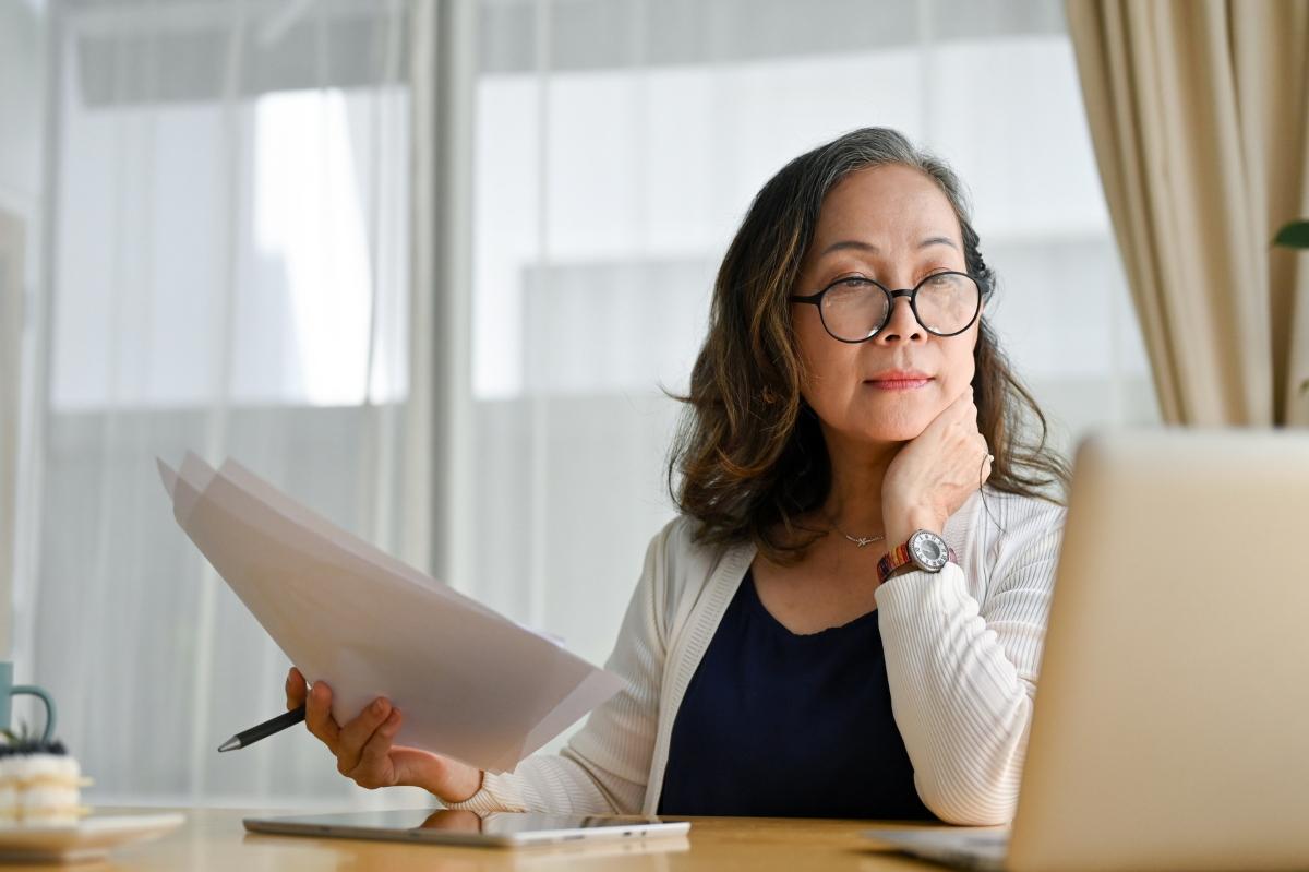 A woman looking at infinite banking information on a laptop