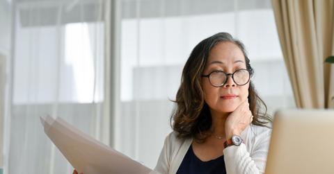 A woman looking at infinite banking information on a laptop