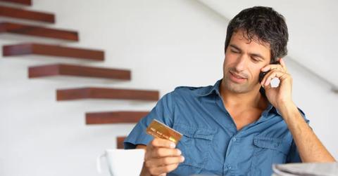 A man in blue requests credit limit increase on phone.