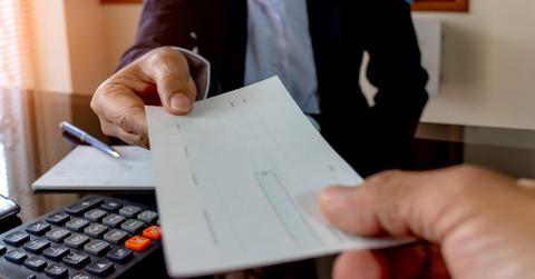 An employer giving out a paycheck