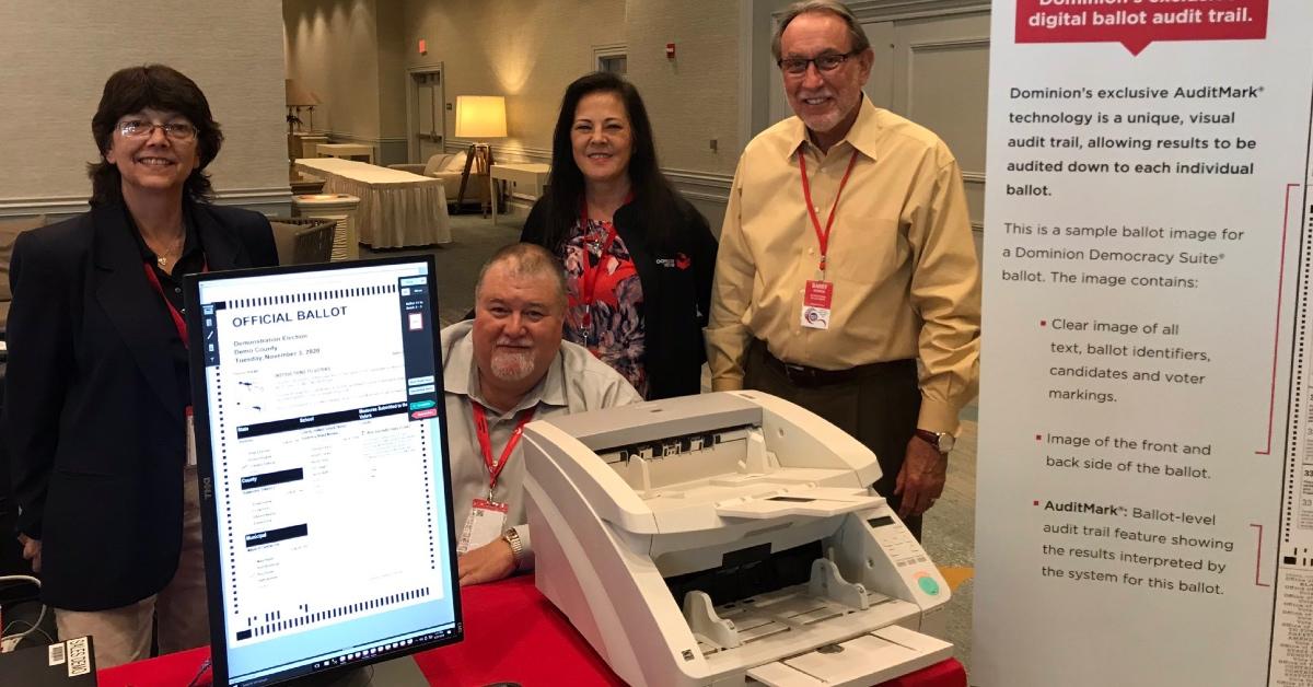 The Dominion Voting team gathers around a voting machine at the 2019 FSASE Summer Conference.