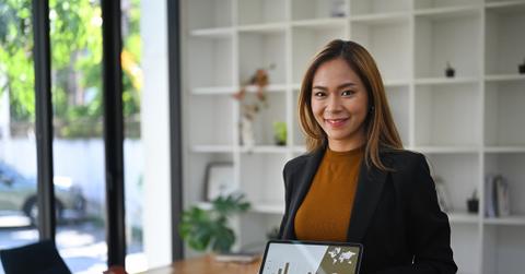 A woman holding a tablet with data on crypto taxes