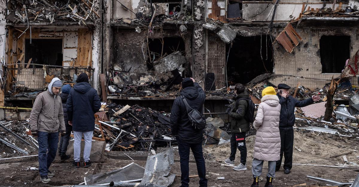 People look at the exterior of a damaged residential block hit by an early morning missile strike on February 25, 2022 in Kyiv, Ukraine.