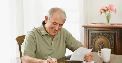 Smiling man with bill and checkbook