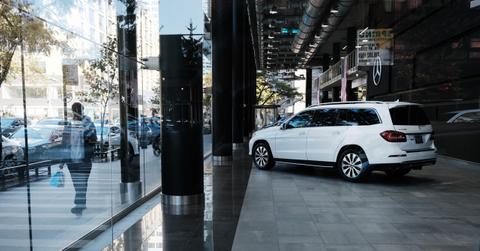 A man walking past a car dealership showroom