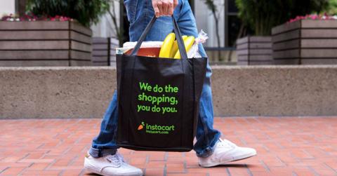 A person carrying an Instacart shopping bag