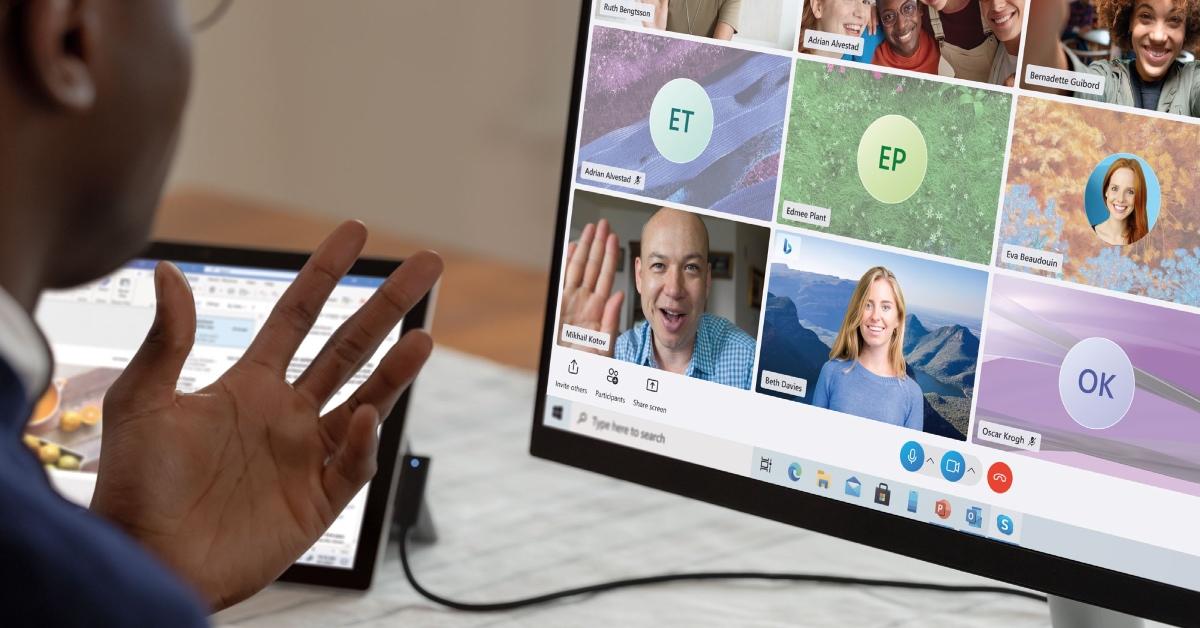 Person sitting at their desk Skyping with others on their computer.