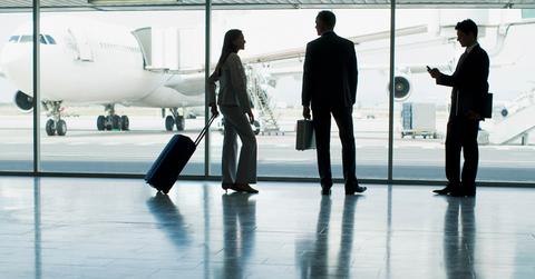 People standing by windows in an airport terminal