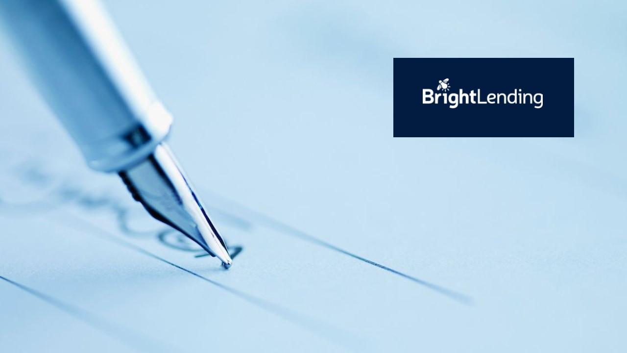 A pen being used to sign a contract and the Bright Lending logo