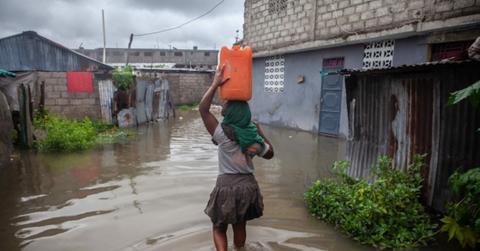 A Haitian woman makes her way through flooded areas after Tropical Storm Grace