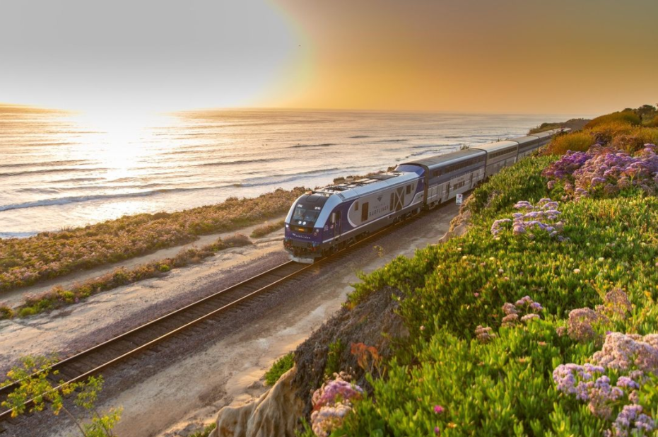 Amtrak train along a coastline at sunset