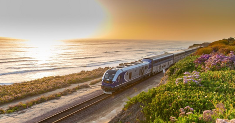 Amtrak train along a coastline at sunset