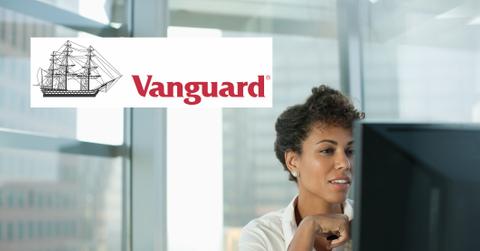 Vanguard logo over investor doing research on VOO VTI ETFs