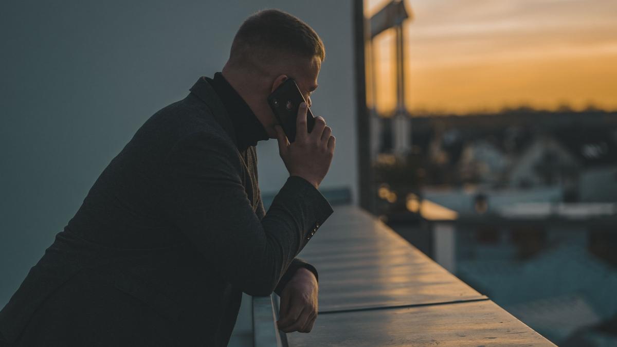 A man on phone in dark jacket