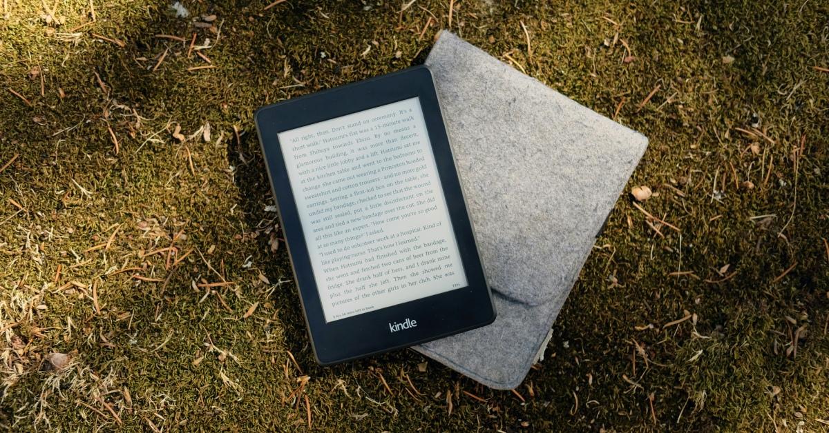 A Kindle device laying on the grass.