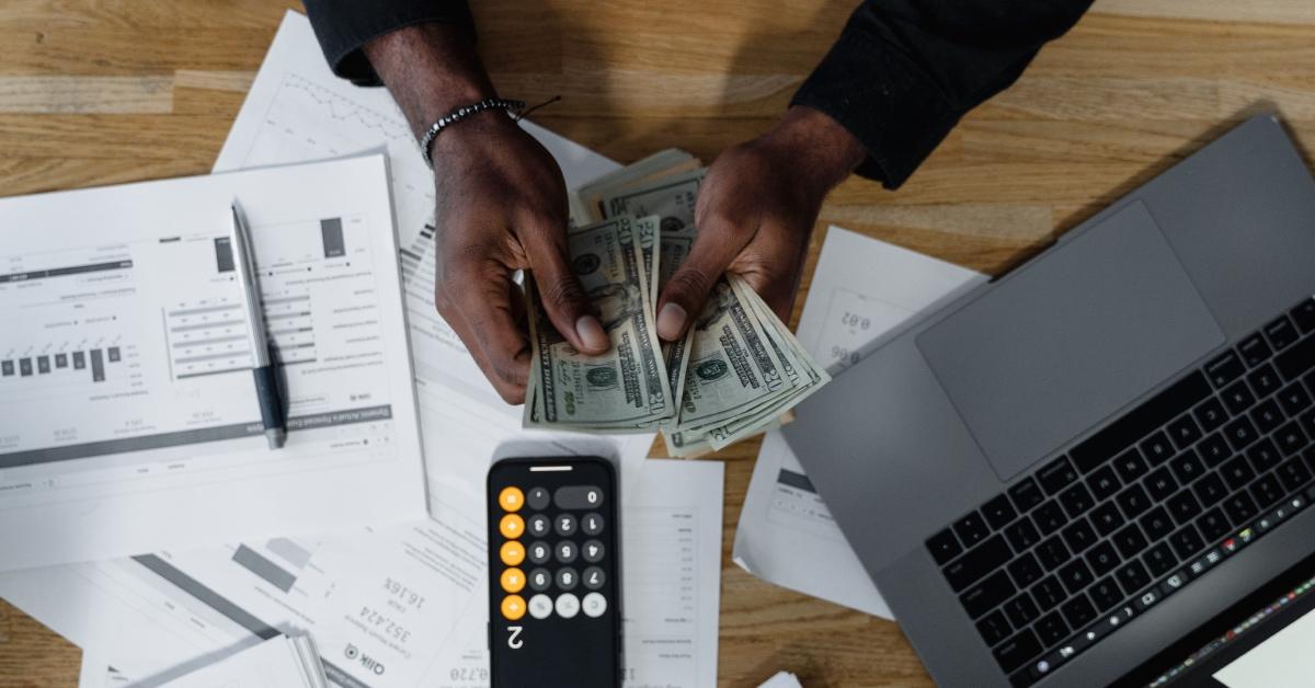 A person counting their severance pay at their desk.