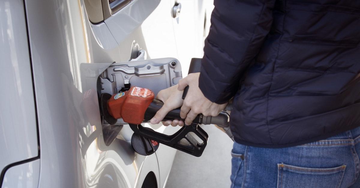 A man putting gas in a vehicle