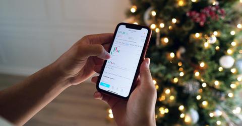 Person checking the stock market schedule on an iphone