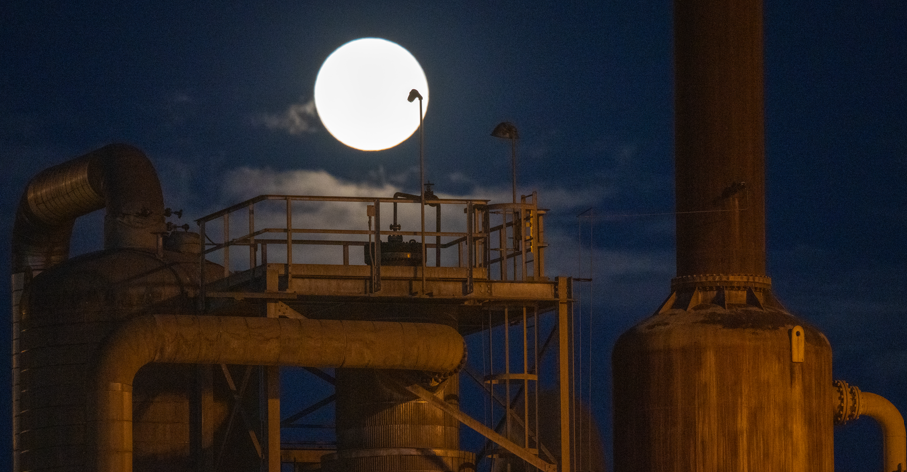 View of the moon above an old power plant