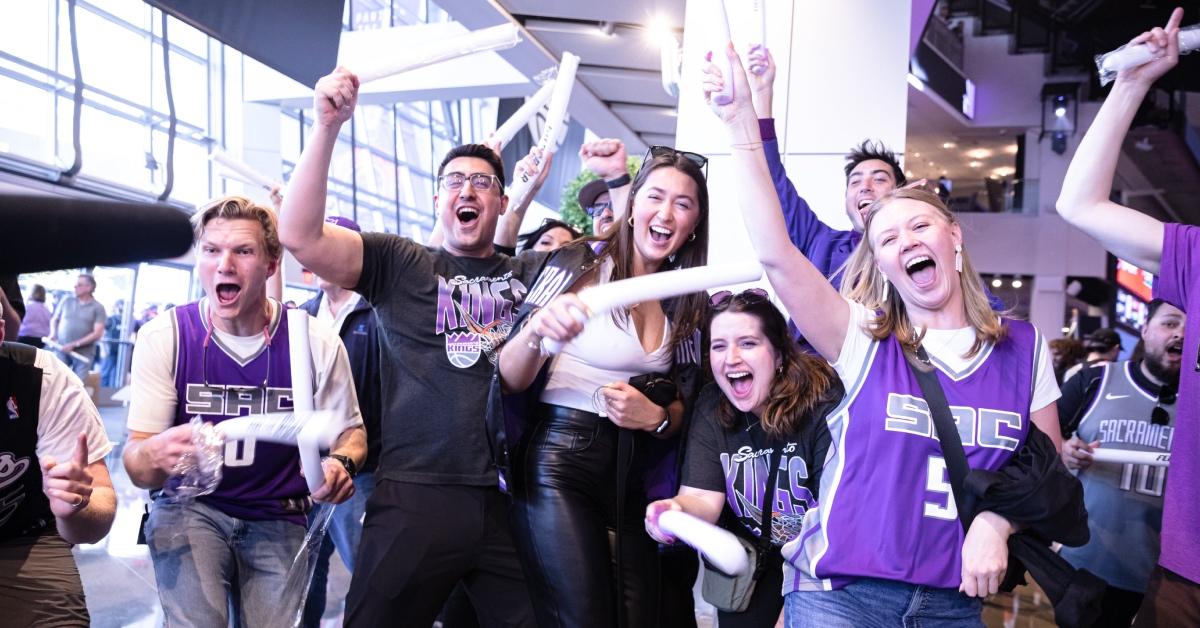 Sacramento Kings fans cheer in excitement in arena lobby.