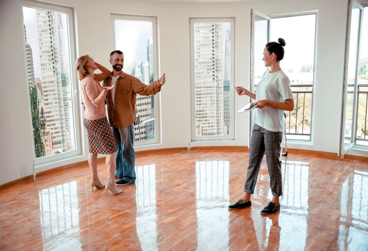 Female realtor shows off an apartment to a couple