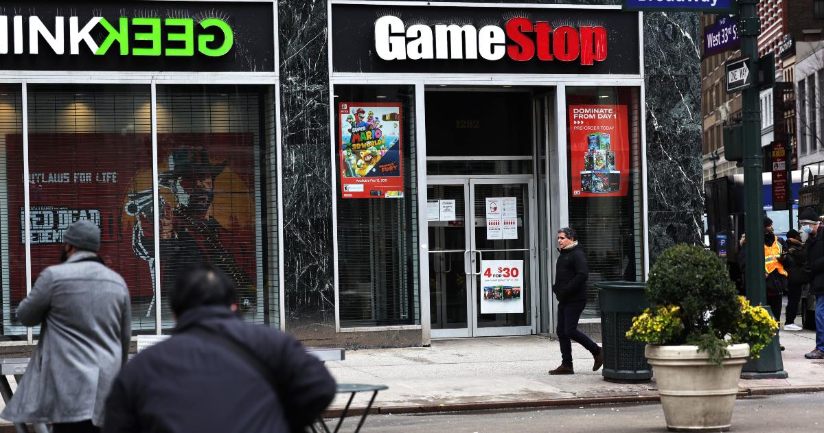 People walking past a GameStop store