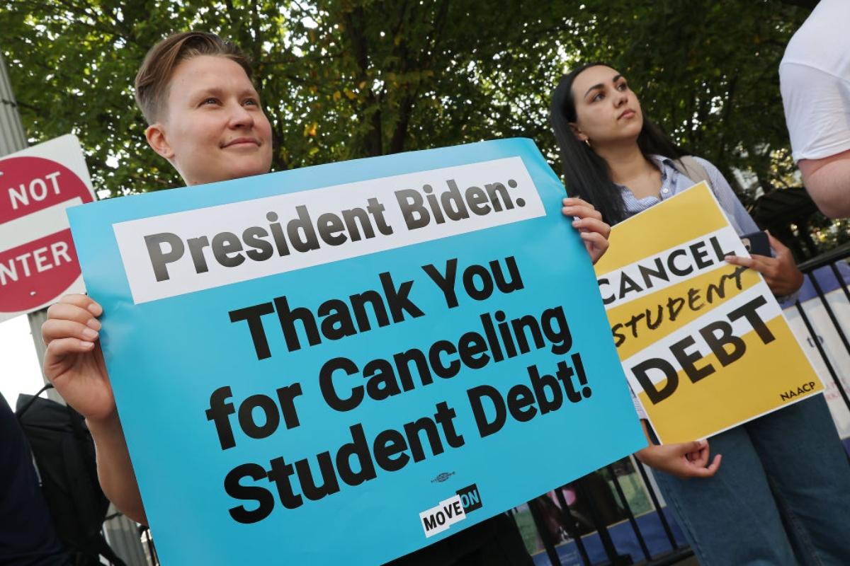 People holding signs about student loan debt