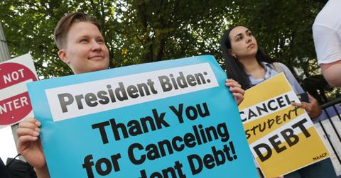 People holding signs about student loan debt