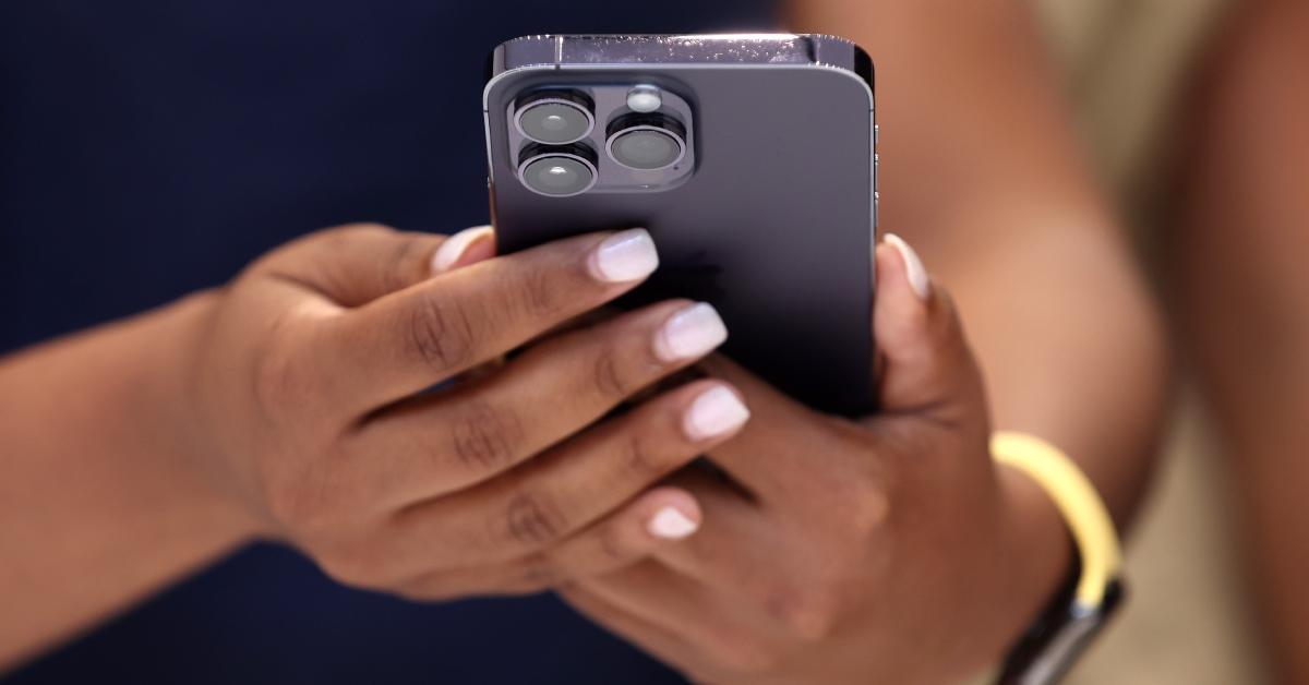 An attendee holds a purple iPhone 14 Pro during an Apple special event.