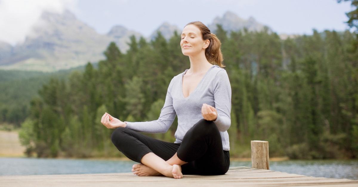 A woman doing yoga on a dock