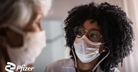 A doctor and patient with the Pfizer logo