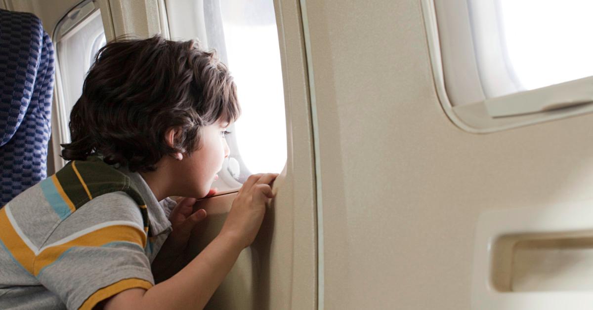 Child looking out airplane window