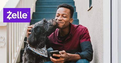 A man with a dog and the Zelle logo
