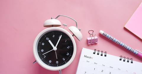 Clock with a calendar on a pink desk