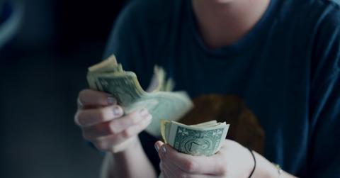 person counting u.s. dollars