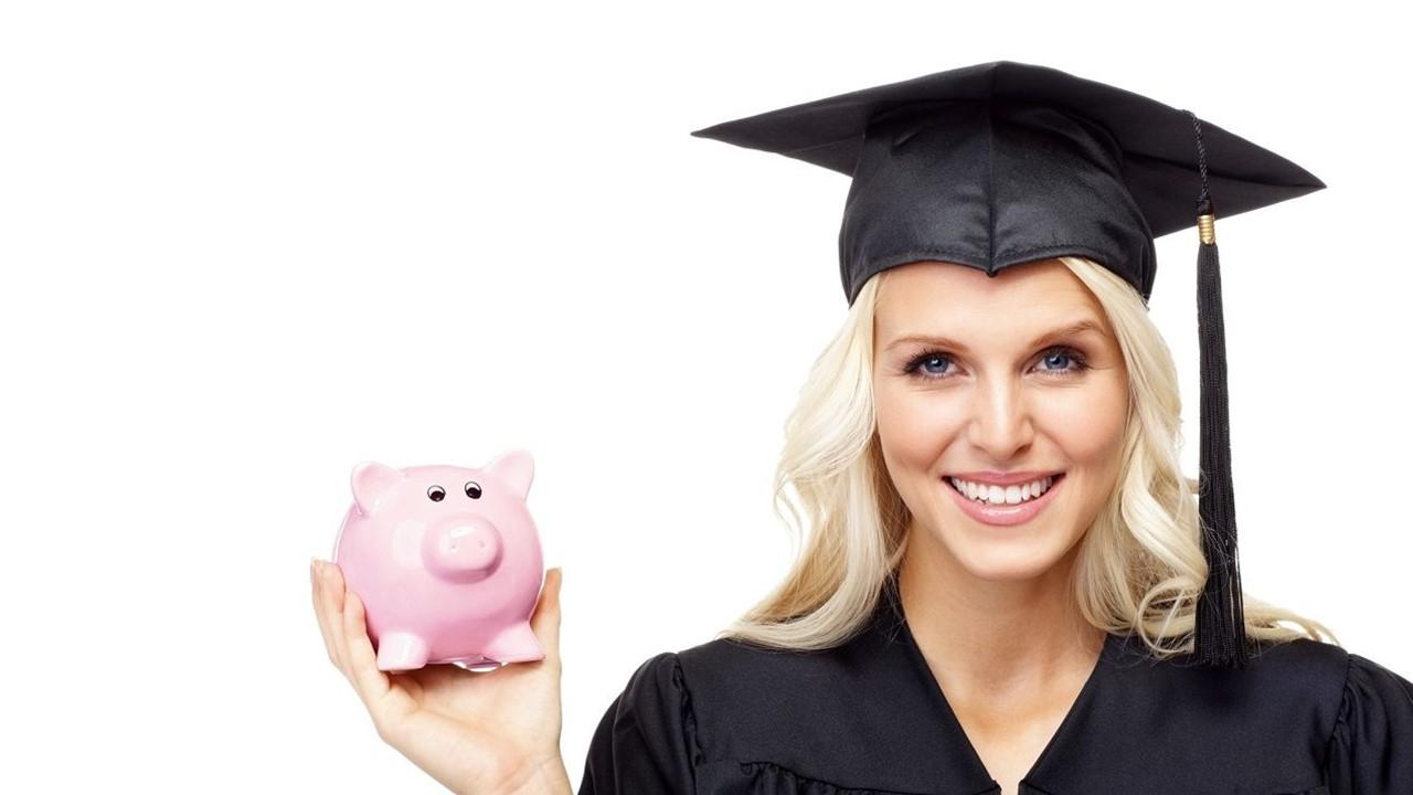 A woman in a cap and gown holding a piggy bank