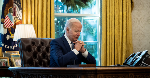President Biden sitting at desk with hands clasped