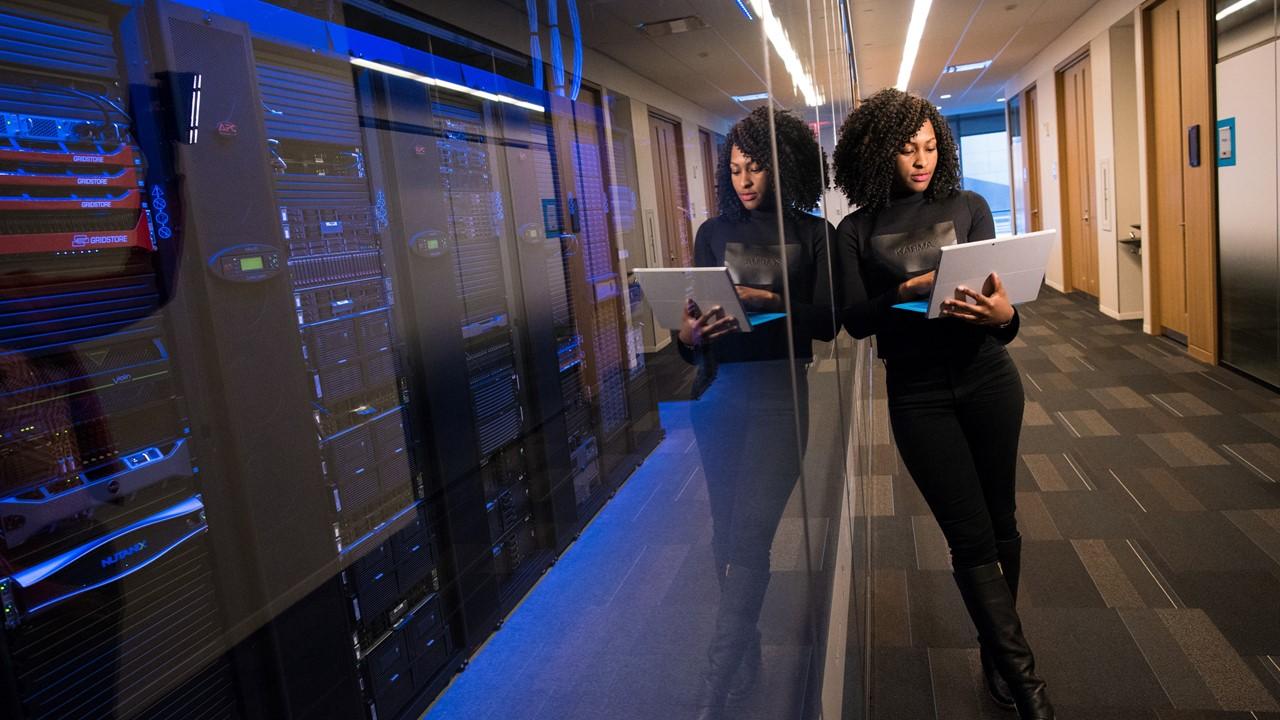 A woman standing beside computer server room