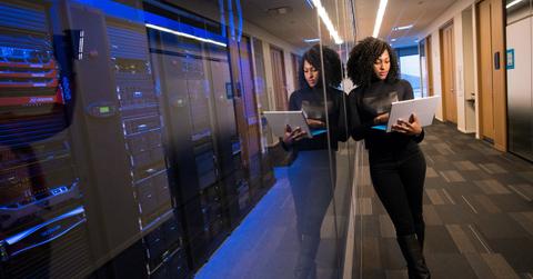 A woman standing beside computer server room