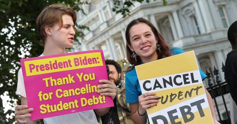 Students holding signs about loan forgiveness