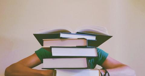 A person sitting at a desk behind books