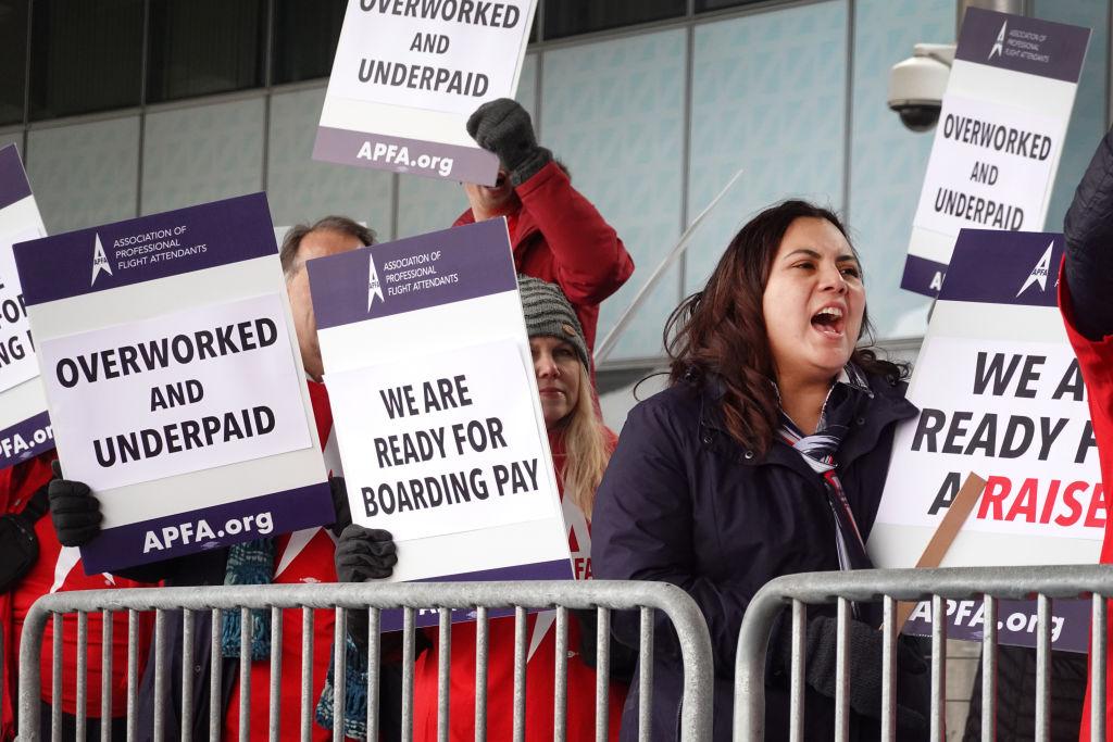 American Airlines employees are seen in a picket line outside of airport gates.